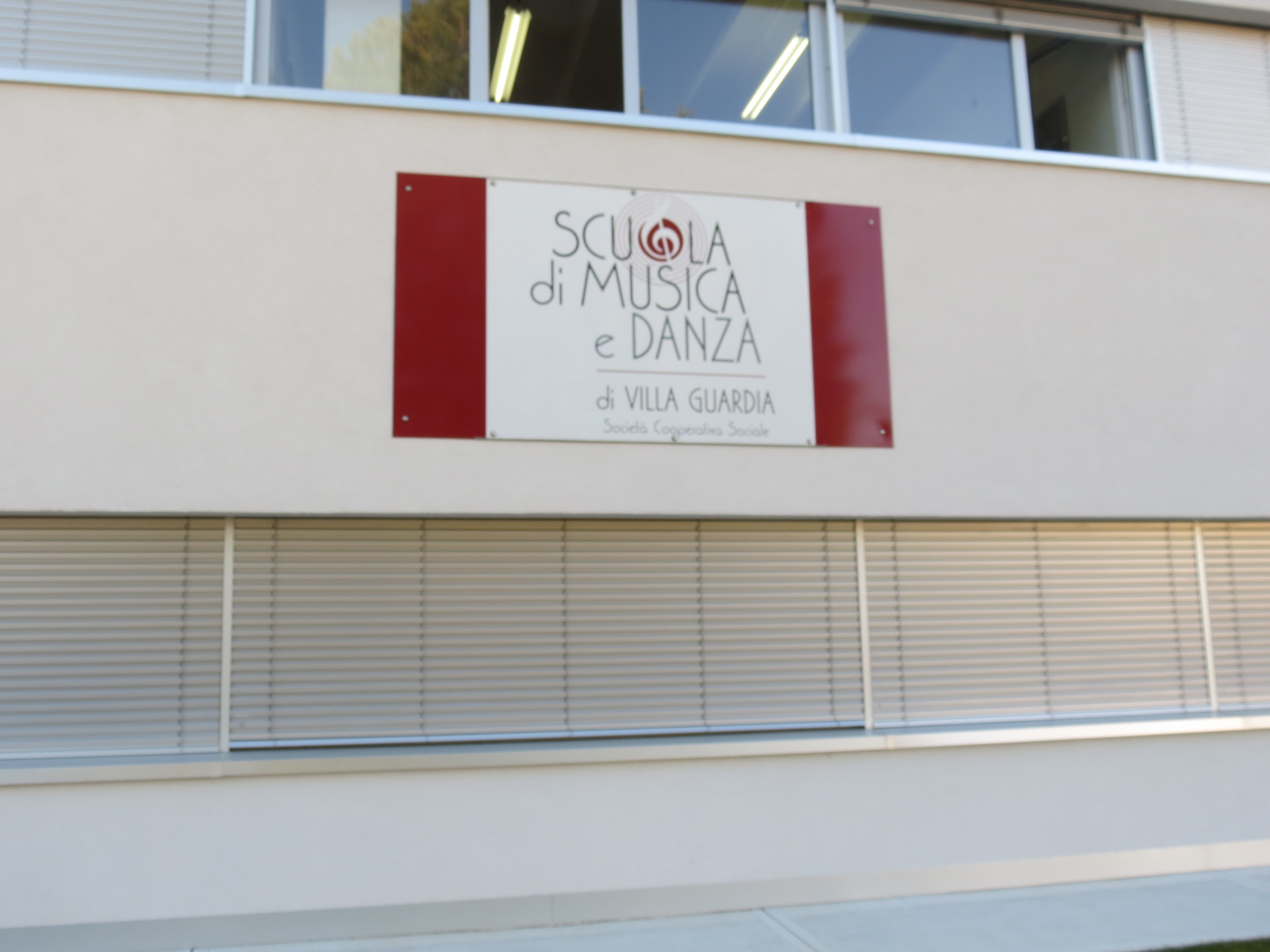 Insegna della Scuola di Musica e Danza di Villa Guardia, affissa su una parete esterna dell'edificio.