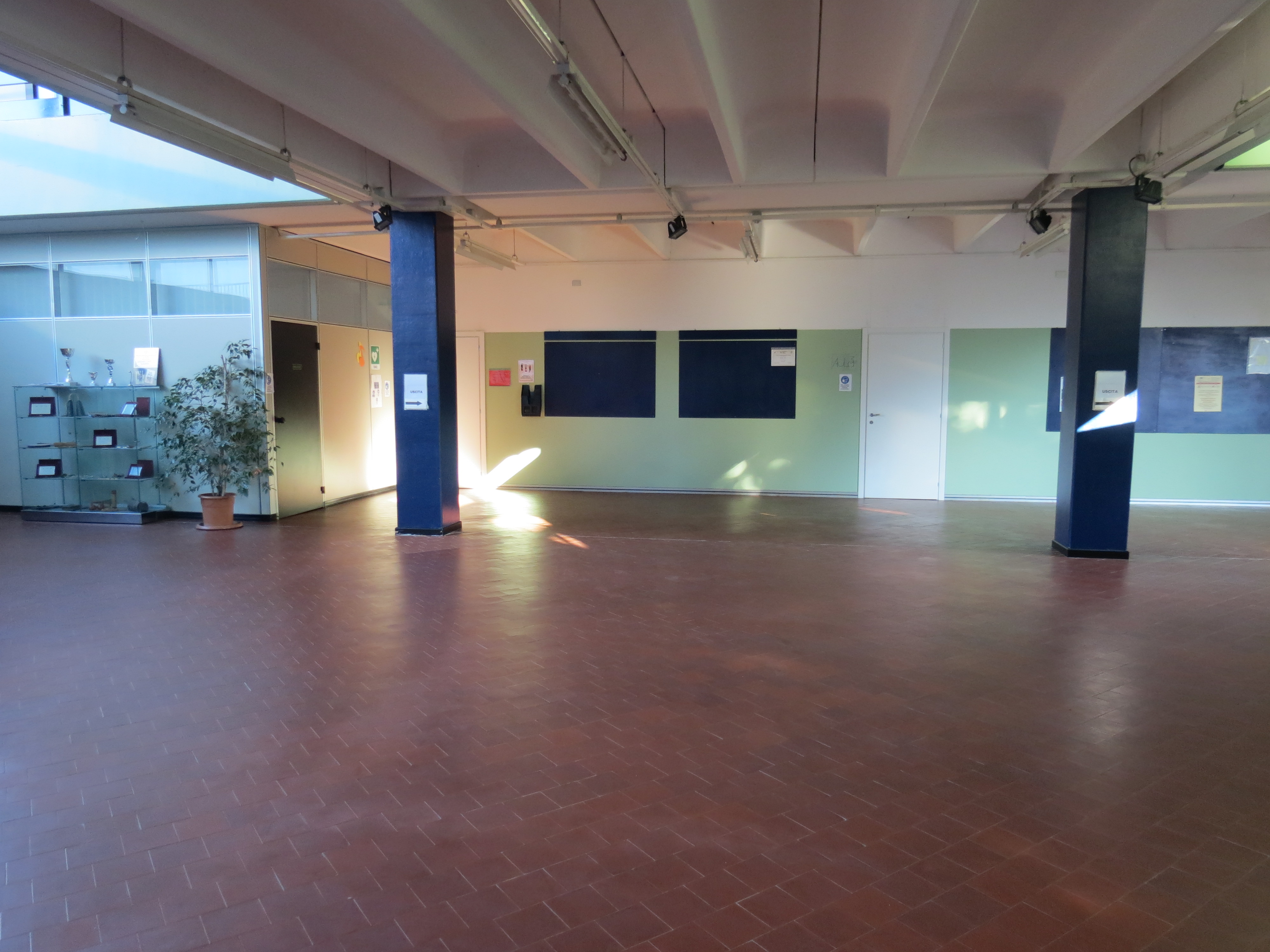 Interno della Scuola di Musica di Maccio a Villa Guardia, con pareti chiare e finestroni che illuminano lo spazio ampio e vuoto.