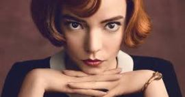 Ritratto di una giovane donna con capelli rossi e occhi intensi, che fissa la telecamera con un'espressione seria, mentre appoggia le mani sul mento.