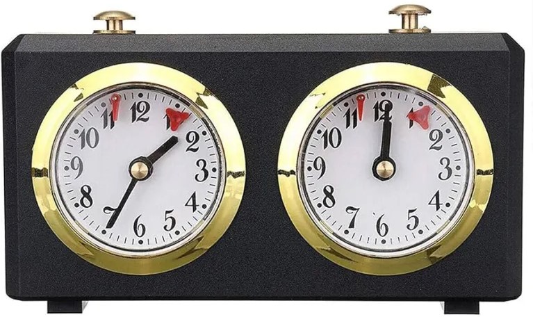 Orologio da scacchi analogico con quadranti bianchi e dettagli dorati, utilizzato per misurare il tempo durante le partite di scacchi.