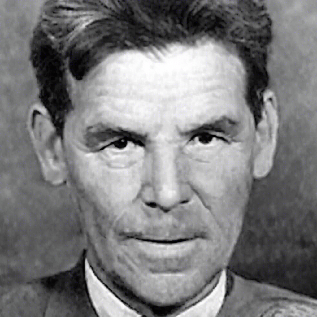 Foto in bianco e nero di un uomo con capelli scuri e un'espressione seria, vestito con un abito formale.