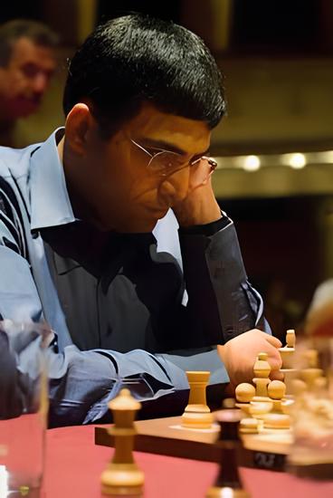 Viswanathan Anand che gioca a scacchi, concentrato sulla scacchiera durante una partita.