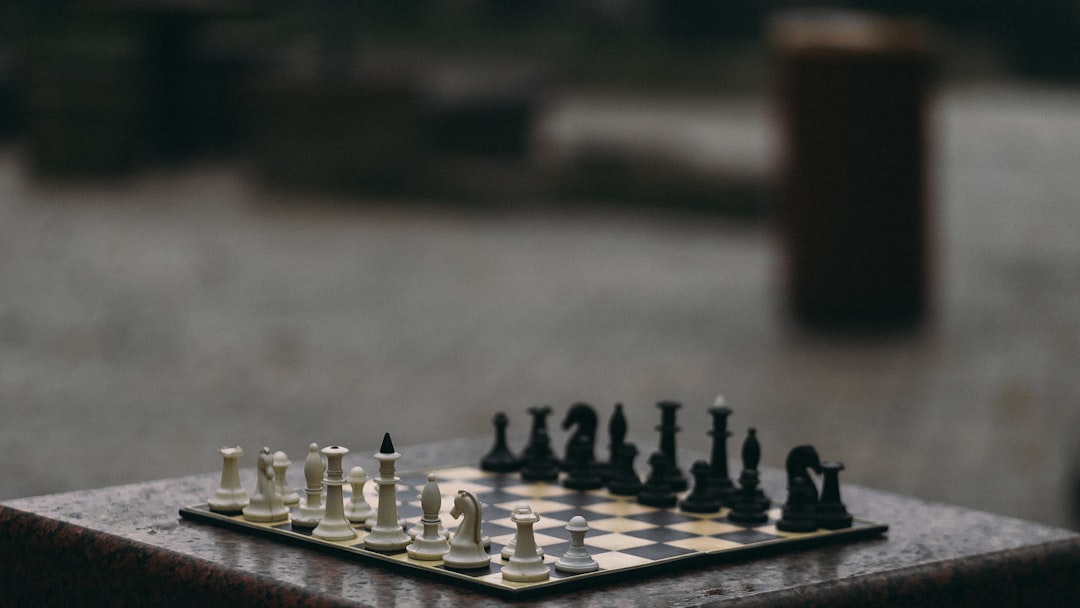 Un'immagine di una scacchiera con pezzi bianchi e neri, posizionata su una superficie in pietra, evocando il tema del gioco degli scacchi e delle decisioni strategiche.