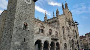 Historic stone building with ornate architecture and a blue sky in the background.