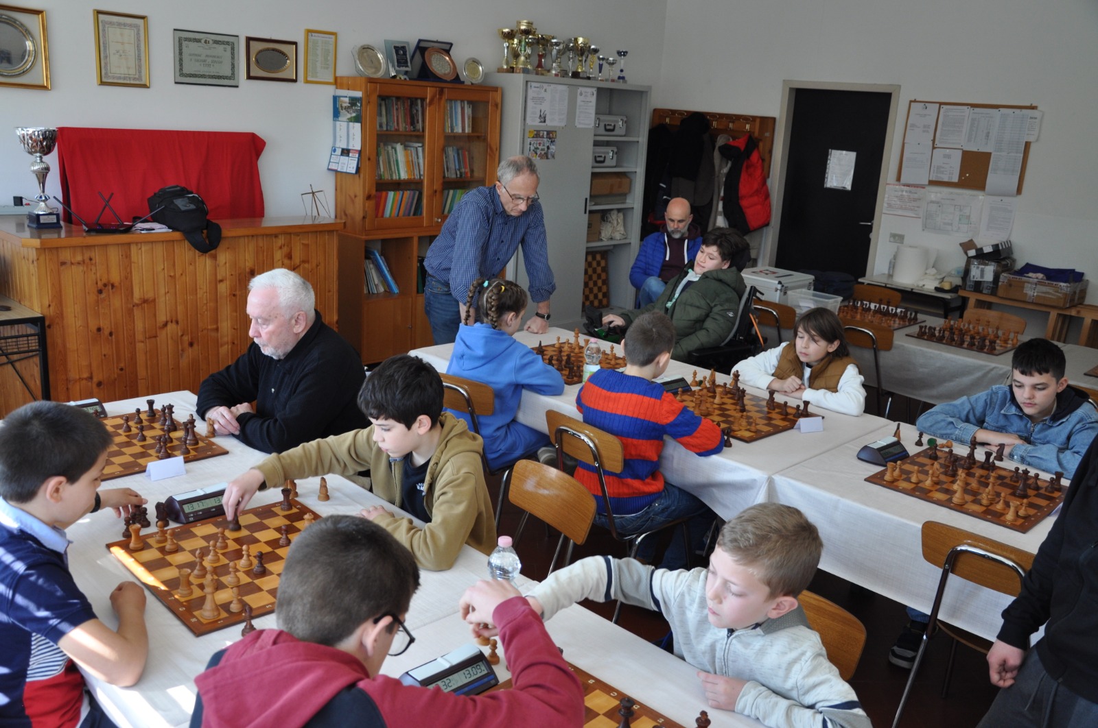 Giocatori di diverse età partecipano a una partita di scacchi in una sala di gioco.