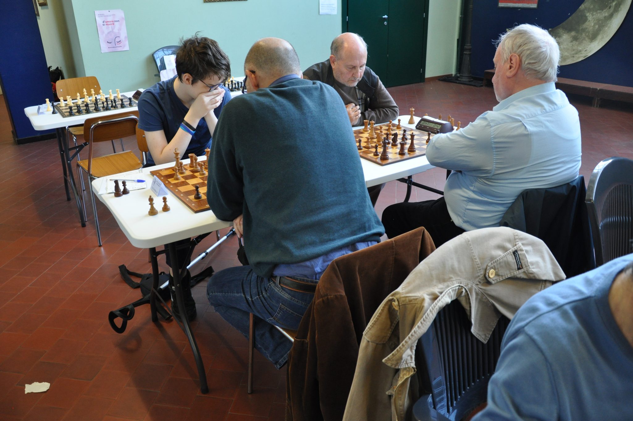 Giocatori di scacchi concentrati durante una partita in un ambiente di competizione.